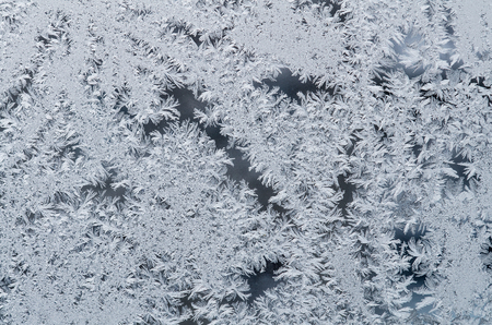 On the glass frozen moisture in the winter day formed a beautiful, fantastic patterns, unpredictable compositions.の写真素材