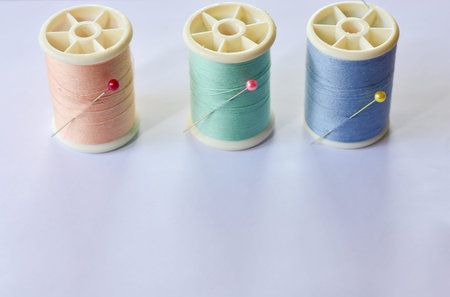 The multi-colored thread is a tailor's sewing device, which has a white background.の写真素材