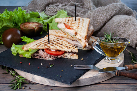 sandwich with meat and fresh vegetables on a wooden table, rustic backgroundの写真素材