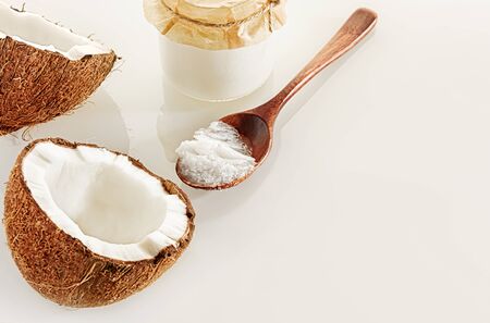 Composition with two halves of coconut, a wooden spoon and jars of coconut butter. The concept of healthy food.の写真素材