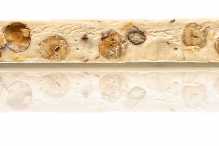 Italian festive torrone (or nougat) with hazelnuts on a white background.の写真素材