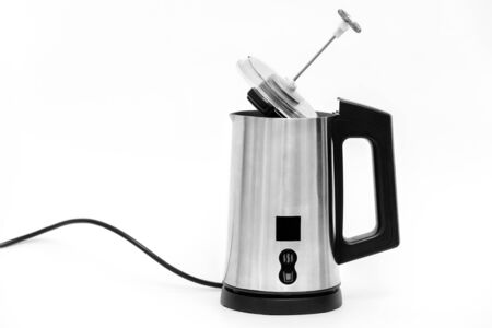 The milk foam maker is automatic.  The frother is made of stainless steel with a black plastic top, handle, buttons and power cord.の写真素材