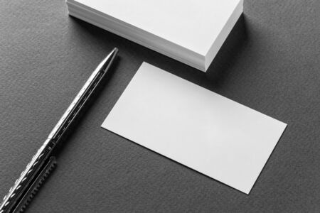 Mockup of business cards stacks arranged in rows and pen on a grey background.の写真素材