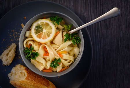 Italian chicken soup with lemon and noodles. Top view.の写真素材