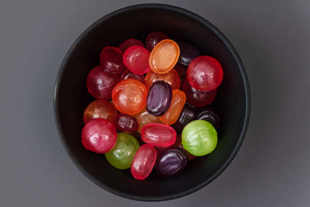 The colorful candies are in a black a bowl. Top view.の写真素材