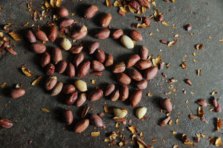 Roasted peanuts. Peanuts are scattered on a dark braun background.Top view.の写真素材