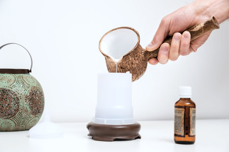 The man's hand is filling with water a capacity of aroma diffuser.