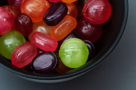 The colorful candies are in a black a bowl.の写真素材
