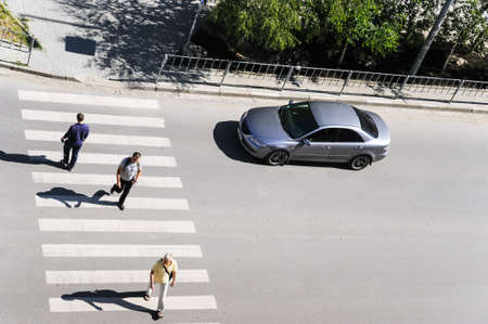 Crosswalk. Top view. Ivano-Frankivsk. Ukraine-23.05.2017. People are crossing a street. A car is waiting for pedestrians.のeditorial素材