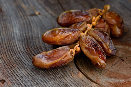 Date branch with dried fruits on an old board. Close up.