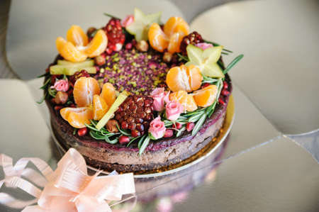 Cake decorated with fresh fruit and flowers in an open box.の写真素材