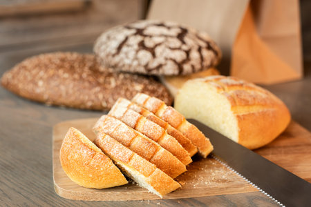 Sliced bread on the table on a background of various breads.の写真素材