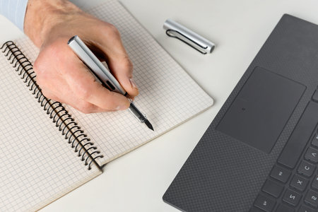 Man at the computer with an ink pen.