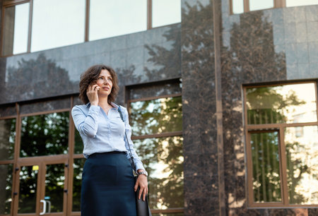Beautiful business woman is talking on a smartphone.の写真素材