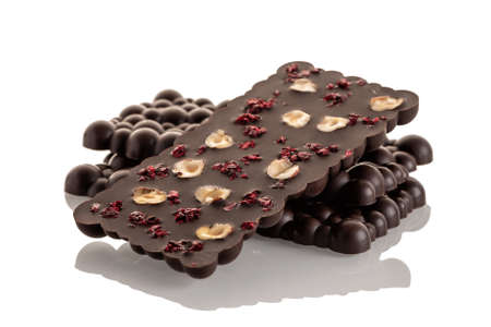 Dark raw chocolate with haselnut and freeze-dried cherries on a white background. Isolateの写真素材