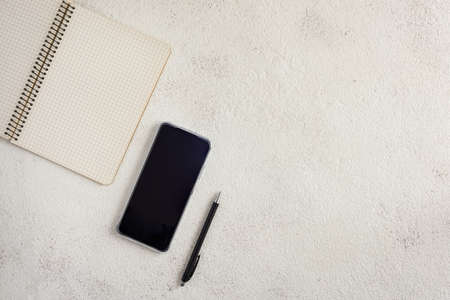 Notebook, smartphone and ballpoint pen on a white background.の写真素材