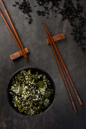Wakame seaweed salad. Bowl and bamboo sticks. Oriental serving. Top view.の写真素材