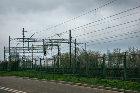 The electrified railway is separated by a fence of metal rods.
