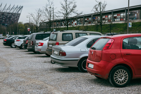 Cars parked in a row. The parking lot is paved with pebbles.の写真素材