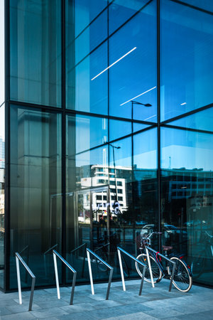 Bicycle parking and bicycle in front of office building windows.の写真素材