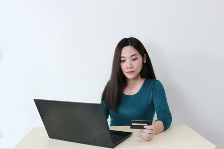 Asian women shopping online using laptop paying by credit card, bakingの写真素材
