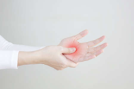 Close up women's hand with pain syndrome , rubbing her inflamed hand.の写真素材