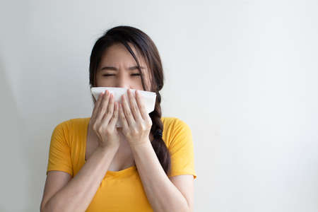 Asian beautiful woman have runny nose and sickness or sneeze with using napkinの写真素材