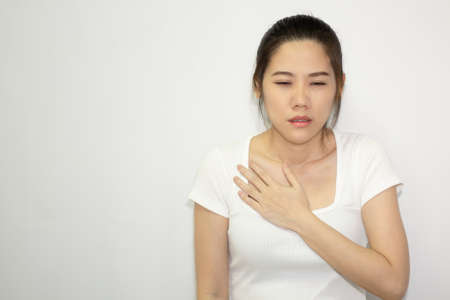 Women clutch chest heart attack symptom. Pain from heart stroke Healthcare and medical concept.の写真素材