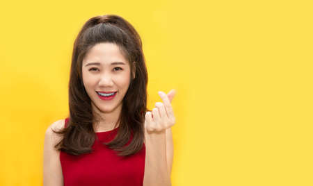 Asian beautiful woman make mini heart gesturing  and express happiness and smiling for valentine's day. Love conceptの写真素材