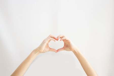 woman's hand make heart gesture and shape on white background. Love sign.の写真素材