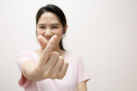 Asian beautiful woman make a mini heart gesturing  and express happiness and smiling for valentine's day. Love concept. Close up heart hand shape gesture.の写真素材