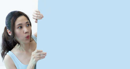 Asian beautiful woman are looking to space area and white signboard for a present a text and promotion.の写真素材