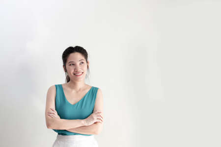 Smart Asian beautiful are cross one's arm with smiling and looking away with confident and positive thinkingの写真素材