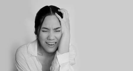 Asian beautiful woman hold her head with hand and crying with feeling sad and hurt. Metal concept and Broken heart.の写真素材