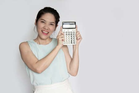 Asian beautiful woman hold calculator with smiling. a Save and finance concept.の写真素材