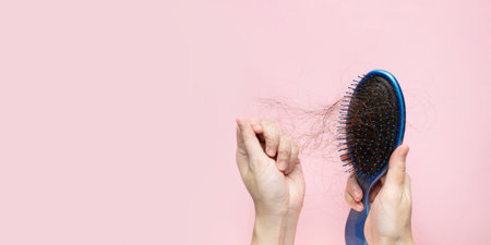 woman hand is removing hair from blue brush. A Hair care.の写真素材