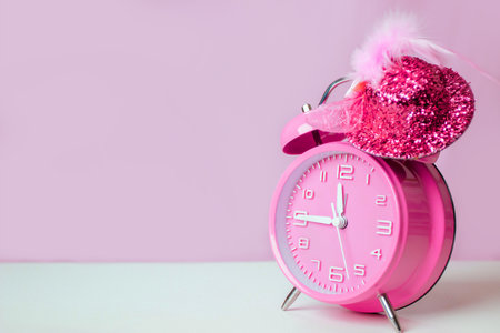A Pink alarm clock with glowing pink hat. Count down time clock for celebrating happy new year.の写真素材