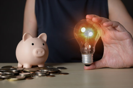Woman holds lightbulb with piggy bank and coin with A Saving money, investment, banking and finance...
