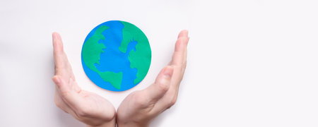 Woman's hand are hold world which made by paper cut to encourage environmental protection and a global warmingの写真素材