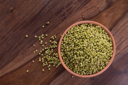 Top View of Fresh Green Tender Sorghum in a Earthen Bowl on Woodenの写真素材