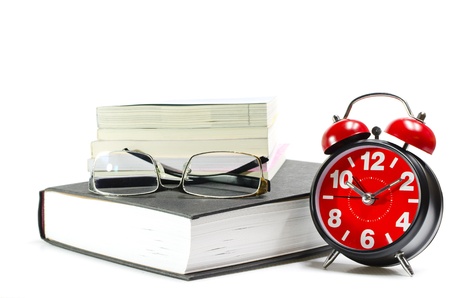 Stack of book and alarm clock,isolated on white   Concept for time to readの写真素材