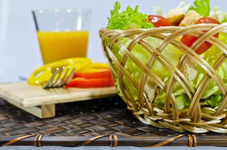 fresh salad in bamboo basket and orange juice,Focus on foreground :Concept for healthy eatingの写真素材