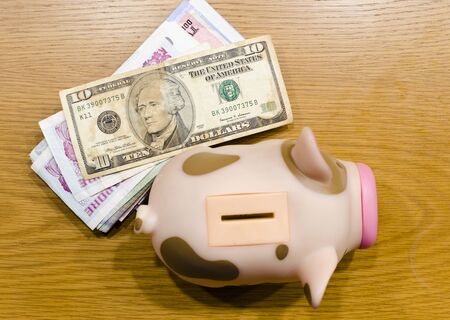 Piggy bank  and Banknote on wood table ,photograph on top viewの写真素材