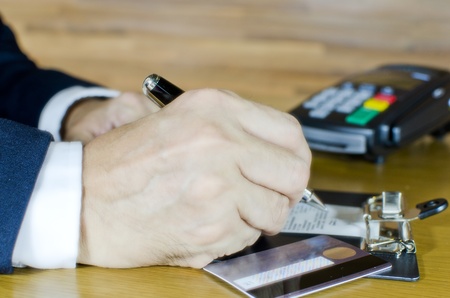 Business man writing credit card sale slip on clipboardの写真素材