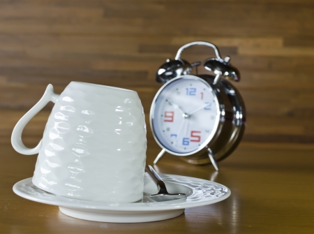 Empty Coffee cup and Alarm Clock on the table, Concepts for morning wakeupの写真素材