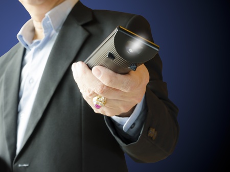 Business man using remote control ,isolated on blue backgroundの写真素材