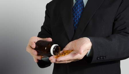 Businessman taking medical pills , isolated backgroundの写真素材