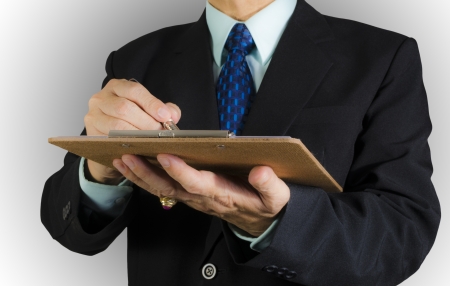 business man writing paper on clipboard ,isolated backgroundの写真素材