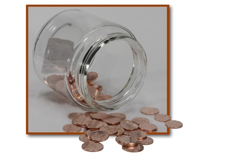 copper coins out of glass jar , isolated on white backgroundの写真素材
