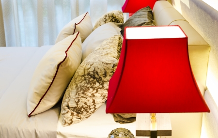Pillows on the bed and decorative lighting lampの写真素材